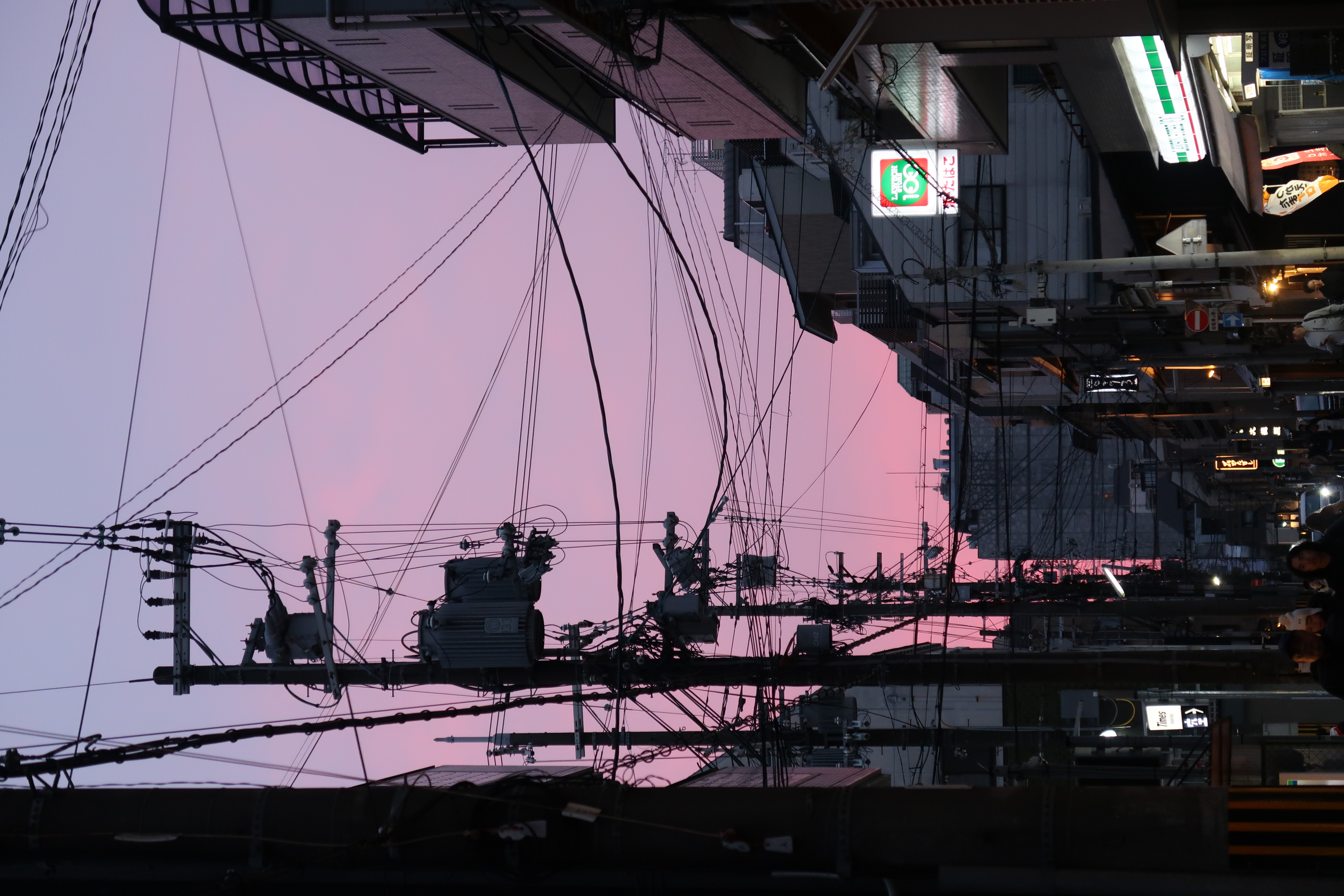 A pink sunset over a city street in Kyoto